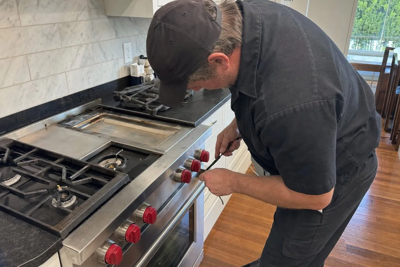 Technician servicing a stainless Wolf range on a same-day visit